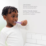 Child brushing teeth with a purple training toothbrush next to copy describing soft bristles and design