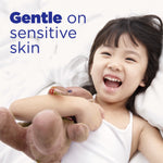 Laughing child holding a stuffed toy on a bed with 'Gentle on sensitive skin' headline for Tide Clean & Gentle