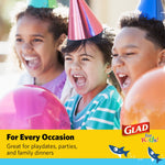 Children wearing party hats and holding balloons with Glad logo and shark graphics in banner