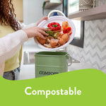 Lifestyle photo of a person emptying food scraps from a white Chinet paper plate into a countertop compost bin, with 'Compostable' graphic.