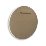 Back of a circular wall plaque showing brown fiberboard backing with a horizontal hanging slot and white painted edge