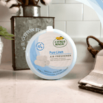 Citrus Magic Pure Linen air freshener canister styled on a countertop with decorative props in a home setting