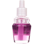 Close-up of a clear glass fragrance refill bottle showing pink liquid and internal wick for plug-in diffuser