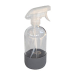 Clear reusable glass spray bottle with translucent trigger and dark gray rubber base on white background