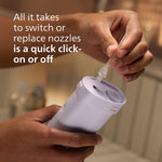 Hands demonstrating clicking a clear replacement nozzle onto a Philips Sonicare compact flosser body in a bathroom setting.