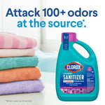 Clorox Laundry Sanitizer bottle next to folded colorful towels with headline 'Attack 100+ odors at the source' in blue text