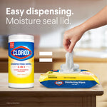 Lifestyle image showing a hand pulling a wipe from a Clorox soft pack beside a Clorox canister with text about easy dispensing and moisture seal lid.