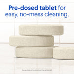 Close-up of stacked pre-dosed round toilet cleaning tablets on a tiled surface with headline about no-mess cleaning.