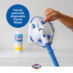 Hand attaching a disposable Clorox wipe to the triangular scrubber head, with a Clorox wipes canister blurred in the background.