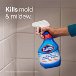 Hand holding a Clorox Clean-Up spray bottle aimed at tiled grout with on-image text 'Kills mold & mildew.'