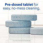 Stacked close-up of blue speckled pre-dosed toilet cleaning tablets on tiled surface with product copy above