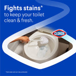 Toilet bowl being scrubbed with a brush and foam inside the bowl, set inside a Clorox branded graphic about fighting stains.