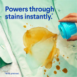 Hand pouring Clorox2 cap onto a stained green shirt with text 'Powers through stains instantly' and visible stain pretreat demo.