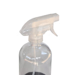Close-up of a clear glass spray bottle neck and translucent trigger showing interior dip tube