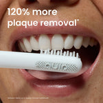 Close-up of a mouth with a Quip toothbrush head near the teeth and text claiming “120% more plaque removal.”