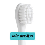 Close-up macro of a white electric toothbrush replacement head showing dense soft bristles with 'Soft Bristles' label.