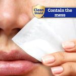 Close-up of a hand holding a Kleenex tissue to the side of a person's nose with 'Contain the mess' Clean Shield label