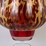 Close-up detail of tortoiseshell pumpkin warmer surface and red refill bottle section beneath