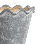 Close-up of scalloped wavy rim and upper wall of a gray textured ceramic planter