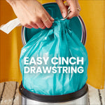 Close-up of hands cinching the drawstring on a bright teal trash bag in a small silver bin with 'EASY CINCH DRAWSTRING' text