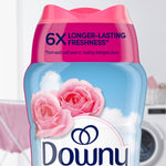 Close-up of the top half of a Downy April Fresh bottle showing pink cap, roses and brand logo