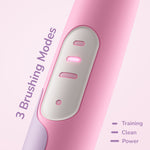 Close-up of the pink toothbrush handle showing three illuminated mode indicator lights and a power button on a soft pink background.