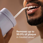 Close-up of a person using a Philips Sonicare flosser tip near their teeth, showing the nozzle in use.