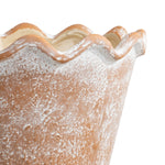 Close-up of scalloped wave rim and textured whitewashed terracotta surface of a ceramic planter