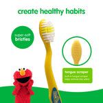 Close-up of yellow Sesame Street toothbrush head and handle showing super-soft bristles and inset tongue scraper with Elmo graphic
