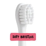 Close-up of a white electric toothbrush head showing dense soft bristles with ‘soft bristles’ label