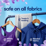 Clothes on hangers and a towel on a rack with text 'safe on all fabrics', promoting Downy CALM fabric safety.