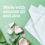Flat lay of coconut halves, aloe, jars and white tissues with text 'Made with coconut oil and aloe'