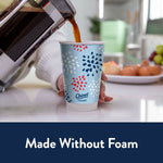 Coffee being poured into a Chinet Comfort patriotic paper cup held on a kitchen counter