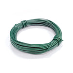 Close-up of a coiled green vinyl-coated garden tie wire resting on a white surface, showing texture and ties
