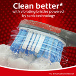 Close-up of Colgate 360 toothbrush bristles shown vibrating with water and foam against a red background