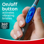 Close-up of a hand pressing the on/off button on a Colgate 360 Vibrate toothbrush handle