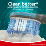 Close-up of Colgate 360 Vibrate toothbrush bristles with water droplets and text “Clean better with vibrating bristles”