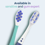 Overhead view of two toothbrush heads, one green-handled sensitive option and one white-handled gum expert, with availability text