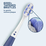 Close-up of Colgate Gum Expert toothbrush head and handle with magnified inset showing dense tapered bristles