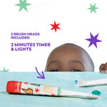 Colgate kids toothbrush lying on surface with extra brush head and a child peeking over background with feature text