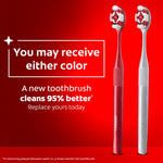 Two Colgate Optic White toothbrushes, one red and one light gray, with text "You may receive either color" on a red background.