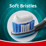 Colgate toothbrush head shown with a dollop of toothpaste above the soft blue and white bristles and text “Soft Bristles”