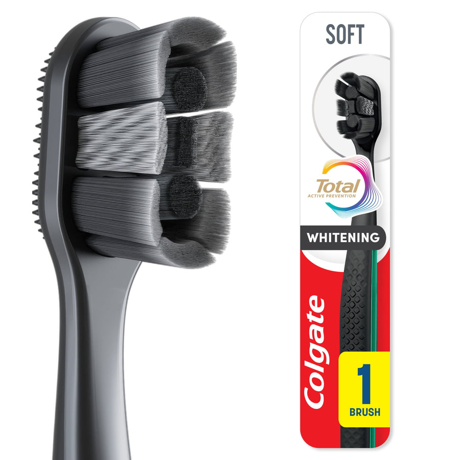 Close-up of a black Colgate Total Active Prevention soft toothbrush head showing dense soft bristles and textured handle.