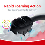 Black Colgate Total toothbrush demonstrating rapid foaming action with foam and blue accent lighting over stylized teeth.