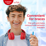 Teen with braces holding a blue Colgate Wisp soft pick, promotional text notes the product is convenient for braces.