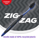 Diagonal view of a blue Colgate ZigZag toothbrush with black charcoal bristles over ZigZag branded background and recycled handle note