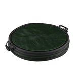 Dark green collapsible pop-up trash can shown collapsed flat with zipper and carry handles visible