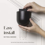Hands installing a black Command Décor wall planter over adhesive strips with copy ‘Easy install - no tools needed’