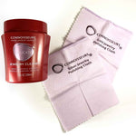 Red Connoisseurs jewelry cleaner bottle beside two branded pink polishing cloths on a white background