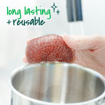 Hand holding a copper-coated scouring pad over a stainless steel pot, with overlay text about long lasting and reusable